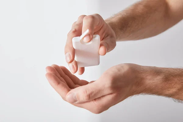 Vista ritagliata di uomo adulto utilizzando disinfettante mano su sfondo bianco — Foto stock