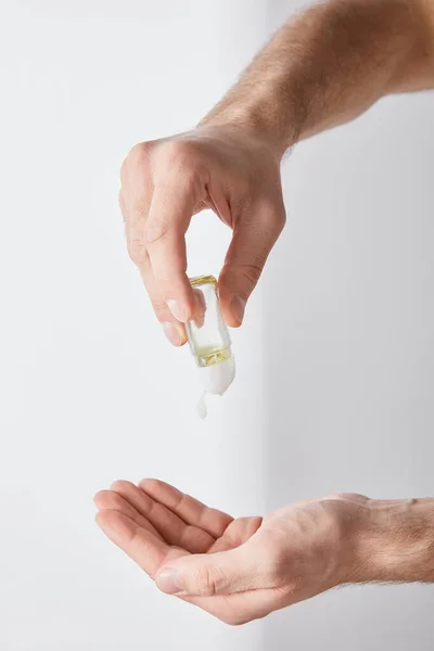 Vue recadrée de l'homme adulte en utilisant un désinfectant pour les mains sur fond blanc — Photo de stock