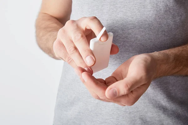 Cropped view of adult man using hand sanitizer isolated on grey — Stock Photo