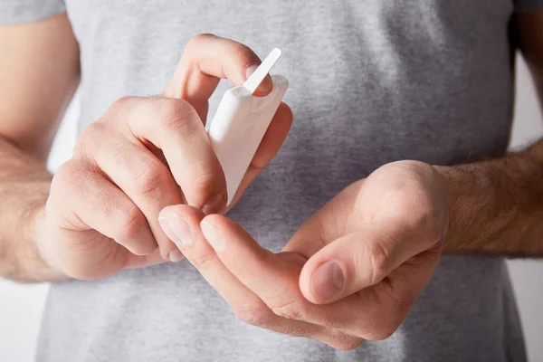 Cropped view of adult man using hand sanitizer — Stock Photo
