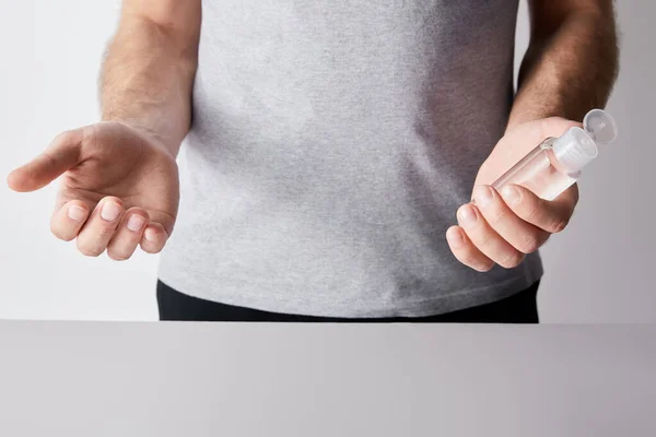 Vue recadrée de l'homme tenant désinfectant pour les mains en bouteille — Photo de stock