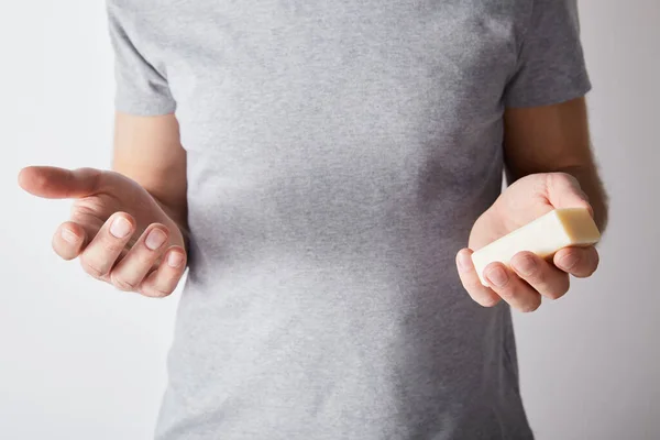 Vista parziale dell'uomo che tiene il sapone su sfondo grigio — Foto stock