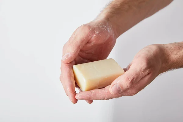 Partial view of man using soap on grey background background — Stock Photo