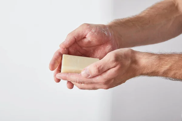 Partial view of man using soap on grey background background — Stock Photo