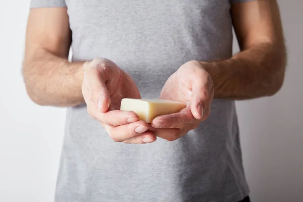 Vue partielle de l'homme utilisant du savon sur fond gris — Photo de stock