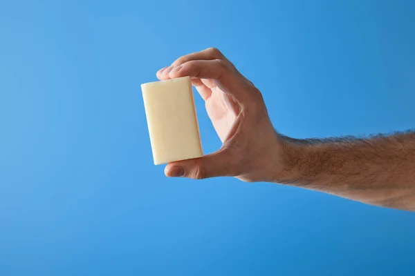 Vista ritagliata di uomo in possesso di sapone isolato su blu — Foto stock