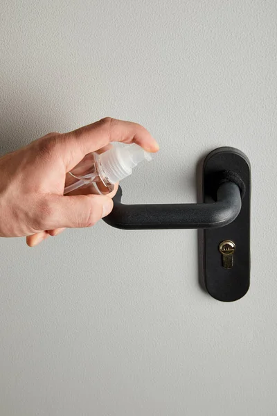 Cropped view of man disinfecting door handle with antiseptic — Stock Photo