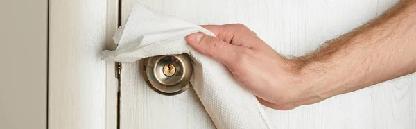 Partial view of man cleaning metal door handle with napkin, panoramic shot — Stock Photo