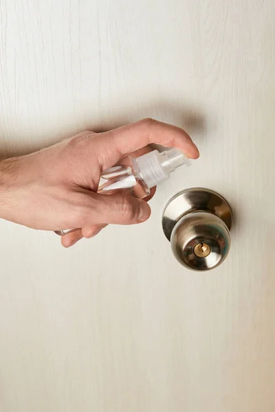Vue recadrée de l'homme désinfectant poignée de porte avec antiseptique — Photo de stock