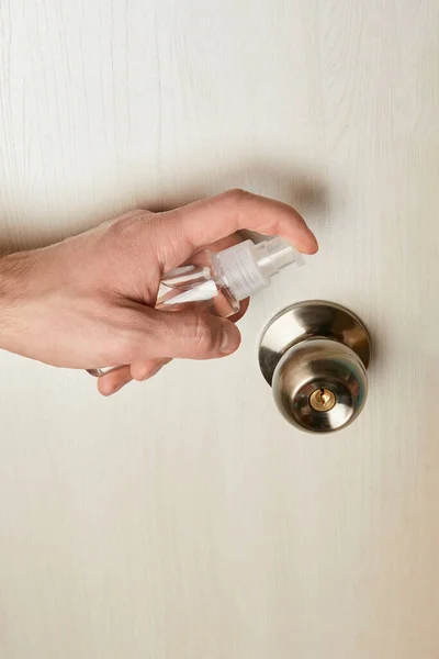 Vista ritagliata dell'uomo disinfettante maniglia della porta con antisettico — Foto stock