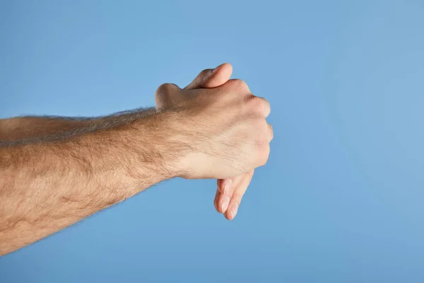 Vista recortada del hombre lavándose las manos aisladas en azul - foto de stock