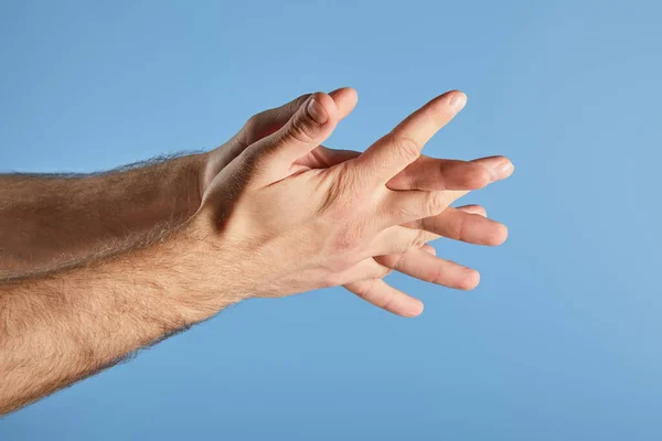 Vista recortada del hombre lavándose las manos aisladas en azul - foto de stock