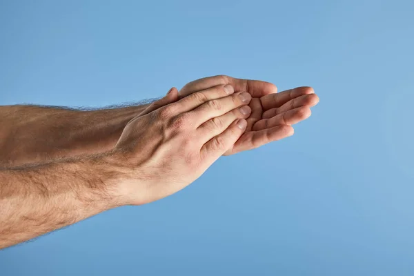 Vista recortada del hombre lavándose las manos aisladas en azul - foto de stock