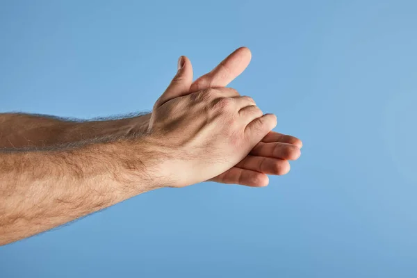 Частичный взгляд человека, моющего руки изолированы на синий — стоковое фото