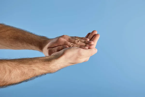 Vista parcial del hombre lavándose las manos aisladas en azul - foto de stock