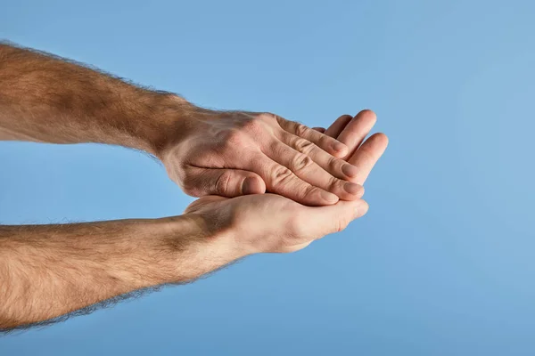 Vista parcial del hombre lavándose las manos aisladas en azul - foto de stock