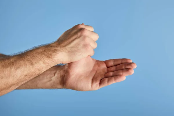 Vista parcial del hombre lavándose las manos aisladas en azul - foto de stock