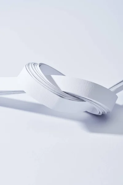 Nahaufnahme von Papierstreifen in Knoten auf weißem Hintergrund — Stockfoto