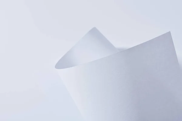 Vista de perto de folha de papel curvo isolado em branco — Fotografia de Stock