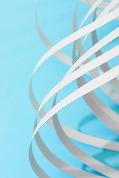 Close up view of white curved paper stripes on blue background — Stock Photo