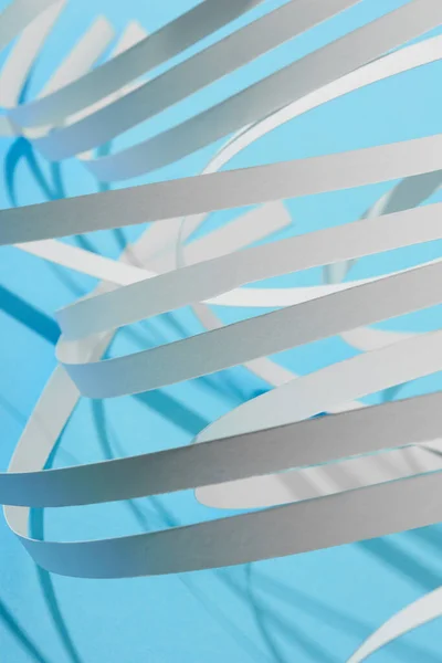 Close up view of white curved paper stripes on blue background — Stock Photo