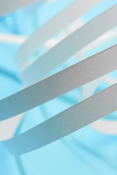 Vista de cerca de las rayas de papel blanco sobre fondo azul - foto de stock