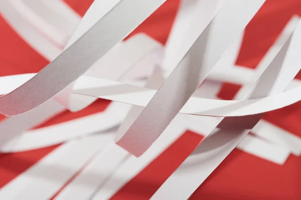 Close up view of white paper stripes on red background — Stock Photo