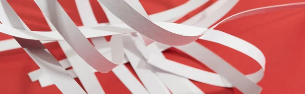 Close up vista de listras de papel branco no fundo vermelho, tiro panorâmico — Fotografia de Stock