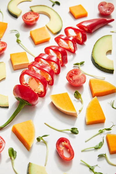 Hohe Blickwinkel auf geschnittenes Gemüse, Mikrogemüse und Avocadoscheiben auf weißem Hintergrund — Stockfoto