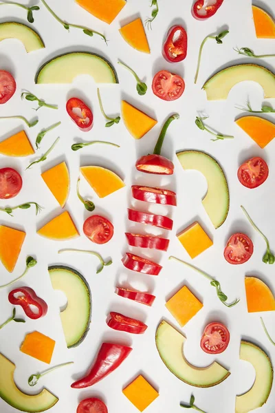 Vista superior de microgreens, verduras cortadas y rodajas de aguacate sobre fondo blanco - foto de stock