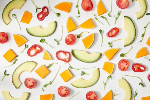 Flache Lage mit Mikrogemüse, geschnittenem Gemüse und Avocadoscheiben auf weißem Hintergrund — Stockfoto