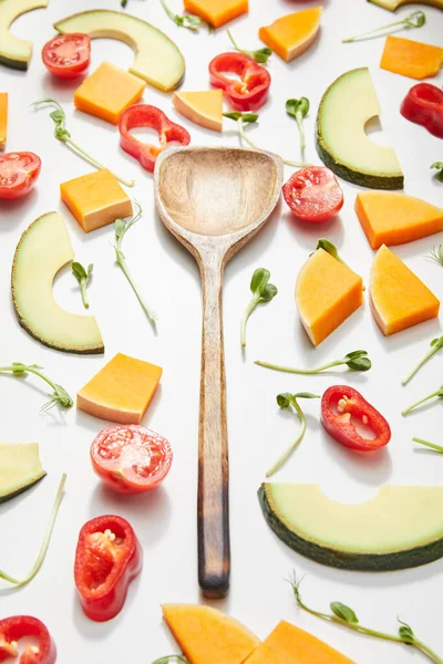 Hochwinkelblick auf Spachtel mit Mikrogemüse, geschnittenem Gemüse und reifen Avocadoscheiben auf weißem Hintergrund — Stockfoto