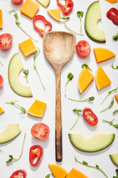 Vue du dessus de la spatule avec microgreens, légumes coupés et tranches d'avocat mûres sur fond blanc — Photo de stock