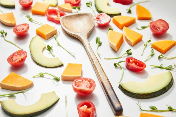 Foco seletivo de espátula com microgreens, cortar legumes e fatias de abacate no fundo branco — Fotografia de Stock