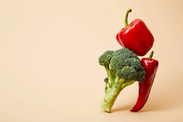 Ripe broccoli, bell and chili peppers on beige — Stock Photo