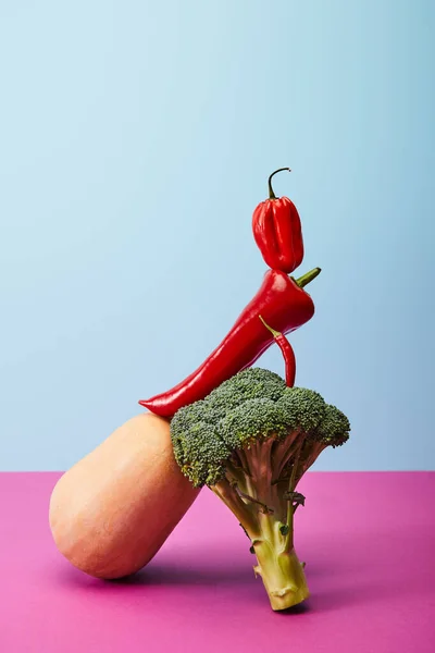 Habanero et piments sur le brocoli et la citrouille sur bleu et rose — Photo de stock