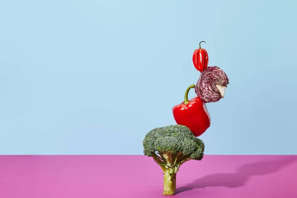 Habanero, die Hälfte Rotkohl und Paprika auf Brokkoli auf blau und rosa — Stockfoto