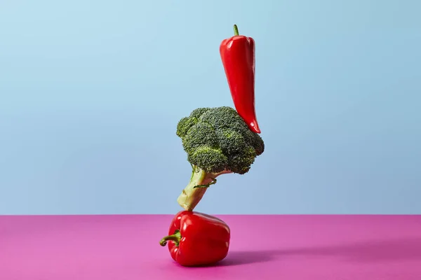 Brocoli mûr, piment et poivrons sur bleu et rose — Photo de stock