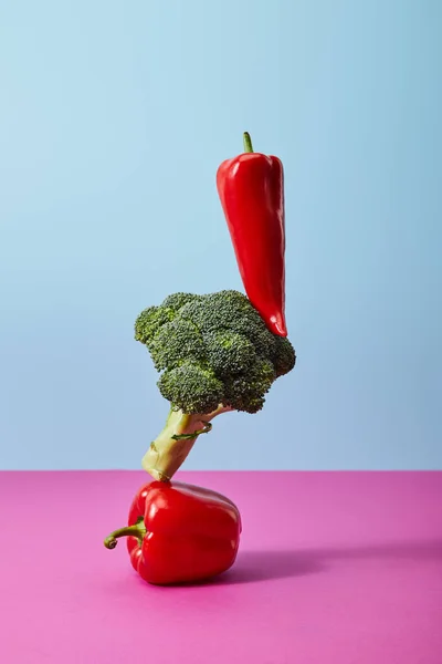 Frische Chilischote auf Brokkoli und Paprika auf blau und rosa — Stockfoto