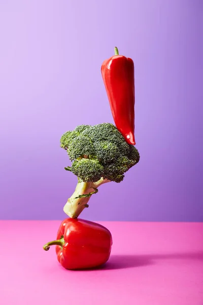 Fresh chili pepper on broccoli and bell pepper on purple and pink — Stock Photo