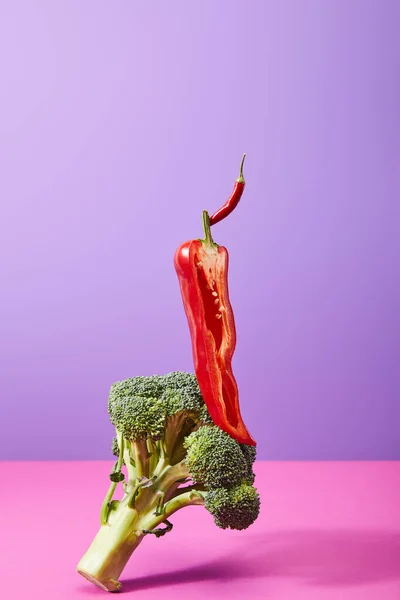 La moitié du piment sur le brocoli cru sur le violet et le rose — Photo de stock