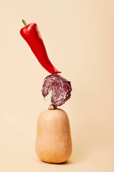 Hot chili pepper, half of red chinese cabbage and pumpkin on beige — Stock Photo