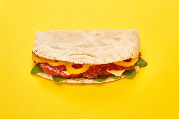 Panino fresco con salame, pita, verdure e formaggio su fondo giallo — Foto stock