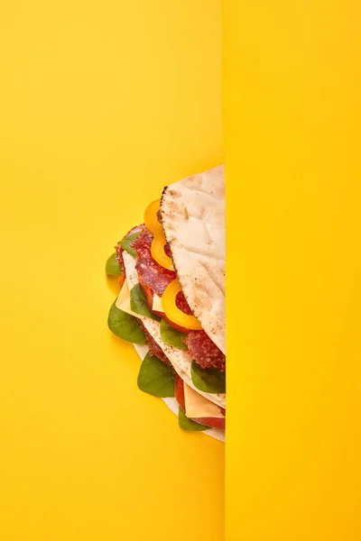 Sanduíche fresco com salame, pita, legumes e queijo em fundo amarelo — Fotografia de Stock