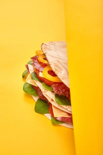 Panino fresco con salame, pita, verdure e formaggio su fondo giallo — Foto stock