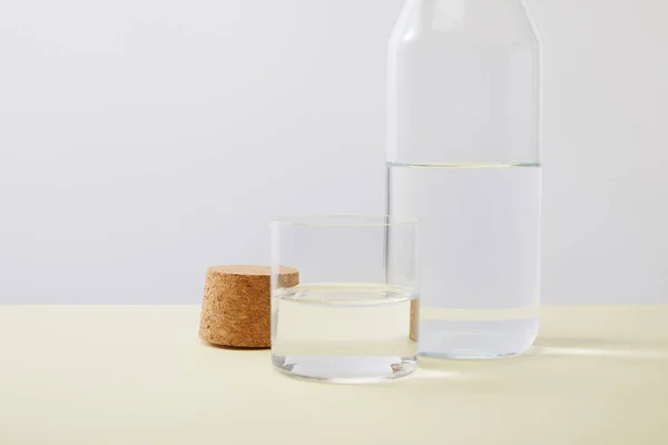 Nahaufnahme von Flasche, Kork und Glas gefüllt mit Wasser isoliert auf grau — Stockfoto