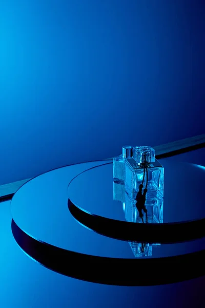 Flacons de parfum bleu sur la surface miroir ronde — Photo de stock