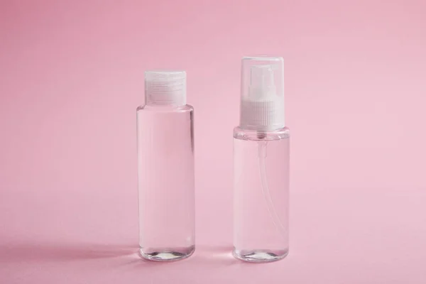 Sanitizer spray and lotion bottle on pink background — Stock Photo