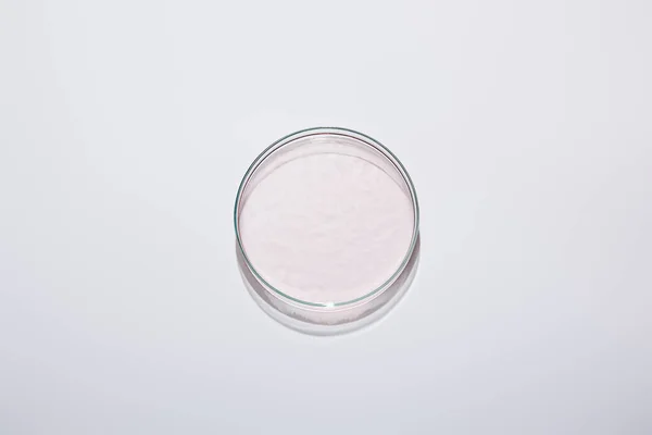 Vue du dessus de la verrerie de laboratoire avec liquide rose sur fond gris — Photo de stock