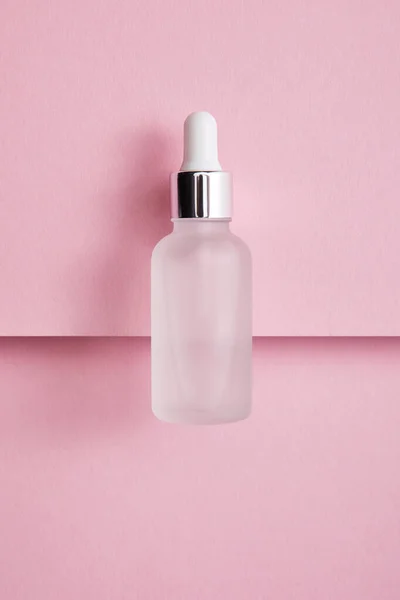 Top view of serum bottle with liquid on pink paper background — Stock Photo